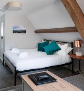 a bedroom with a white bed with blue pillows at New School Rooms estate close to Bath including heated swimming pool,hot tub,WIFI, pool table, parking in Box
