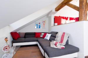 a living room with a gray couch with red pillows at GOLDegg in Goldegg