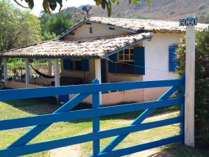 a house with a blue fence in front of it at Pouso Jambo Rosa in Valença