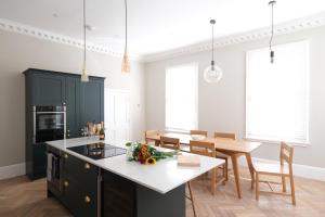 a kitchen and dining room with black cabinets and a table at Dream Stays Bath - Barton House in Bath