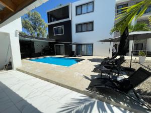 a house with a swimming pool and some chairs at LEVEL suites #4 OMEGA in Sosúa