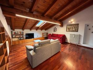 a living room with a couch and a red sofa at La Casa Dell'Acero in Aymavilles