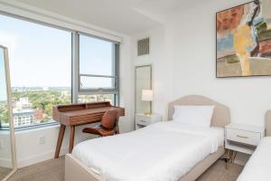 a bedroom with two beds and a desk and a window at Central Penthouse City Skyline Views Gym sleep 8 in Cambridge