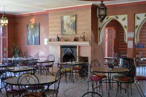 a restaurant with tables and chairs and a fireplace at Le Relais De Marrakech in Marrakesh