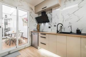 a kitchen with white marble walls and a table at Bakea Home Gran Canaria in Ingenio