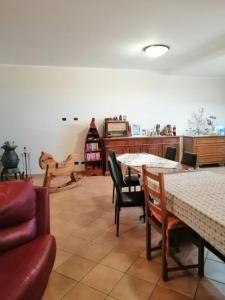 Casa Fontana CervoにあるVilla Saraのリビングルーム(テーブル2台、椅子、ソファ付)