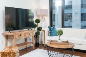 波士顿Back-Bay Upscale Central Condo Bos Common Downtown的客厅里有一张白色沙发和一台电视