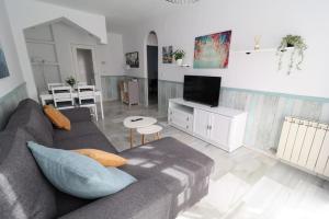 a living room with a couch and a tv at Rincón de Sierra Nevada in Cenes de la Vega