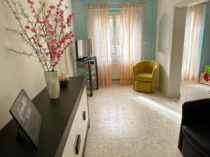 a living room with a vase of flowers on a table at Gîte familial spacieux près de Villandry, avec jardin, pétanque et WIFI - FR-1-381-595 in Lignières-de-Touraine