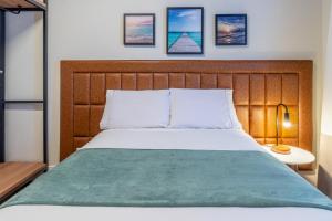a bedroom with a large bed with a wooden headboard at PALMAS EXPERIENCE - APARTAMENTO CONTEMPORÂNEO, vista serra, na quadra do shopping in Palmas