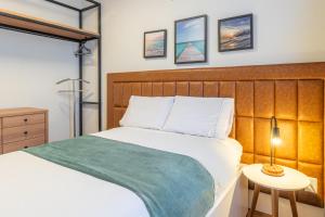 a bedroom with a bed with a green blanket on it at PALMAS EXPERIENCE - APARTAMENTO CONTEMPORÂNEO, vista serra, na quadra do shopping in Palmas