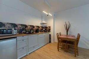 a kitchen with a table and a microwave at Rosa Apart Janów z miejscem parkingowym in Łódź