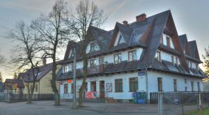 Apartamenty u Piekorza في شافلاري: منزل أبيض كبير على سقف أسود