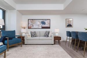 een woonkamer met een witte bank en blauwe stoelen bij Upscale Penthouse near MIT Harvard Central Square in Cambridge