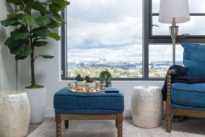 een woonkamer met een blauwe stoel en een raam bij Upscale Penthouse near MIT Harvard Central Square in Cambridge +32 foto's