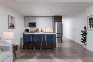 een keuken met een aanrecht en stoelen in een kamer bij Upscale Penthouse near MIT Harvard Central Square in Cambridge