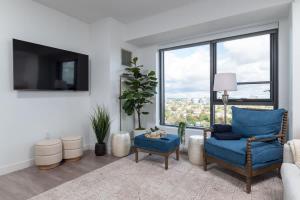 a living room with a blue chair and a large window at Upscale Penthouse near MIT Harvard Central Square in Cambridge +37 photos