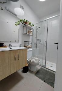 a bathroom with a shower and a toilet and a sink at Buenas Flores Tenerife in Costa Del Silencio +24 photos