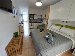 a bedroom with a large bed and a kitchen at Buenas Flores Tenerife in Costa Del Silencio