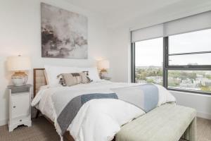 a white bedroom with a bed and a window at Central Penthouse Harvard MIT Spacious Gym & Work in Cambridge