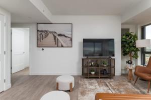 a living room with white walls and a flat screen tv at Central Penthouse Harvard MIT Spacious Gym & Work in Cambridge +36 photos