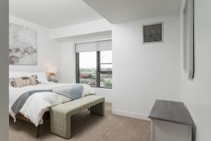 a white bedroom with a bed and a window at Central Penthouse Harvard MIT Spacious Gym & Work in Cambridge