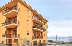 a yellow building with balconies on the side of it at Cozy Apartment In Campo Calabro in Campo Calabro