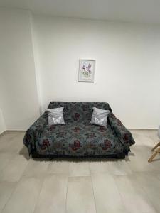 1 cama en una habitación blanca con 2 almohadas en Departamento céntrico San Juan, en San Juan