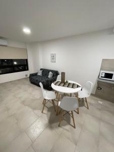 Una sala de estar con una mesa y sillas y un sofá. en Departamento céntrico San Juan, en San Juan