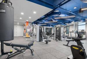 a gym with blue beams and tread machines at Luxury Apartment w King Bed Shared Pool & Rooftop in Cambridge