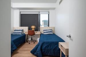a bedroom with two beds and a desk and a window at Luxury Apartment w King Bed Shared Pool & Rooftop in Cambridge +61 photos