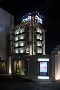 a hotel with a sign on top of it at night at Hotel Lei in Funabashi