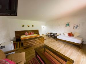 a living room with two beds and a couch at RUSTICA HOTELES CUSCO Urubamba in Urubamba