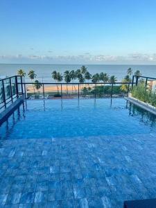 a large swimming pool with a view of the ocean at Melhores Flats - Espaçoso, pertinho do mar in João Pessoa