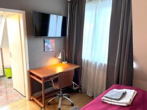 a bedroom with a desk and a television on the wall at Doppelzimmer, eigenes Bad, stadtnahe, ruhig, Airport nahe! in Bönningstedt