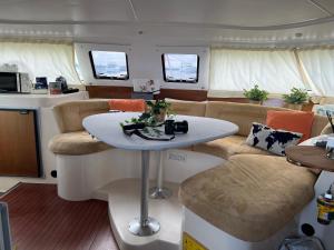 a living room with a table and couch in a boat at Catamaran Corto Maltese III in Lisbon