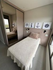 a bedroom with a bed in front of a mirror at Apto Elegante com Localização Privilegiada e Rooftop incrível in Florianópolis +17 photos