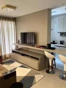 a living room with a kitchen with a counter and chairs at Apto Elegante com Localização Privilegiada e Rooftop incrível in Florianópolis