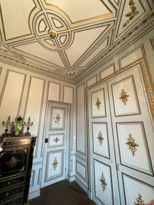 an ornate room with a ceiling with paintings on it at La "Suite" du Château de Chevigny-en-Valière comprenant deux chambres séparées, située à 12 minutes de la célèbre ville de Beaune in Chevigny-en-Valière