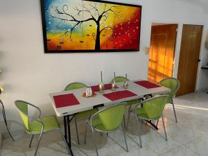 a dining room table with chairs and a painting on the wall at Villa Gloria - Carmen de Apicalá in San Antonio