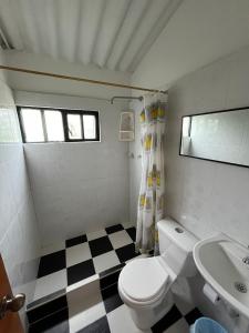 a bathroom with a white toilet and a sink at Villa Gloria - Carmen de Apicalá in San Antonio +18 photos