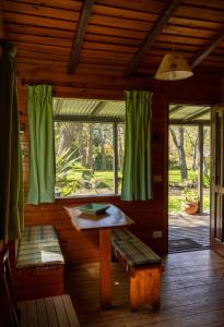 Villa Residencial Laguna BravaにあるLa Casitaのテーブルとベンチと窓のある部屋