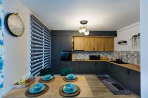 a kitchen with a table and a clock on the wall at Dominic Junior Apartment Sighisoara in Sighişoara