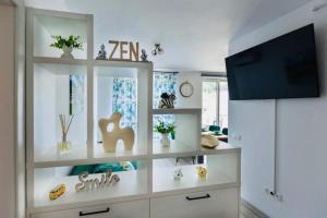 a living room with white shelves and a flat screen tv at Dominic Junior Apartment Sighisoara in Sighişoara +8 photos