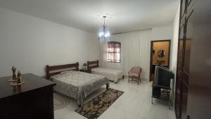 a bedroom with a bed and a tv in it at Pousada Casa da Vó Dita in Ouro Fino +26 photos