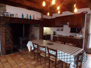 a kitchen with a table and chairs and a fireplace at Villa La Cayrouse Piscine Tennis Boulodrome in Le Bouyssou