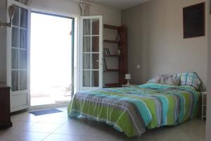 - une chambre avec un lit et une grande porte coulissante en verre dans l'établissement Villa spacieuse à Saint-Florent avec piscine, à Saint-Florent