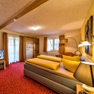 a bedroom with a large bed with yellow pillows at Hotel Sonneneck Titisee -Adults Only- in Titisee-Neustadt