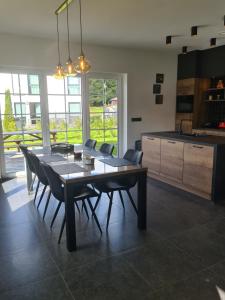 a dining room with a table and chairs and a kitchen at Ferienhaus am Berg in Hohenfels-Essingen