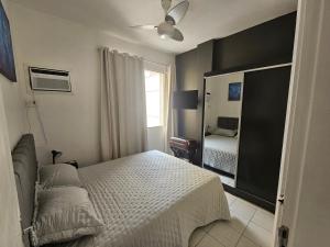 um quarto com uma cama e um espelho em RIO BEM-ESTAR CONFORTO e LOCALIZAÇÃO no Rio de Janeiro